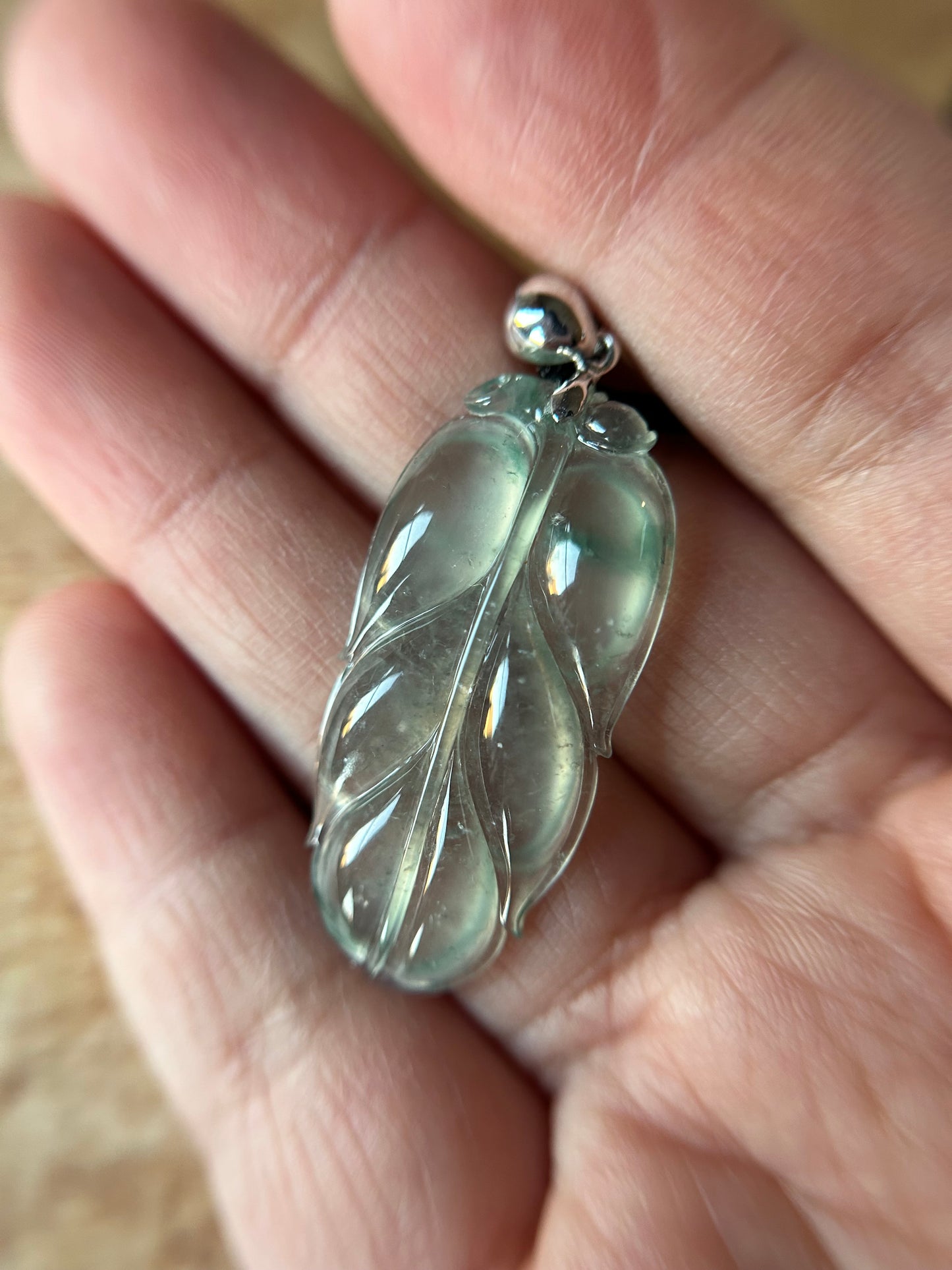 Natural glassy pale green with dark green patches leaf pendant on 18k white gold bail. trusted lab certificate included