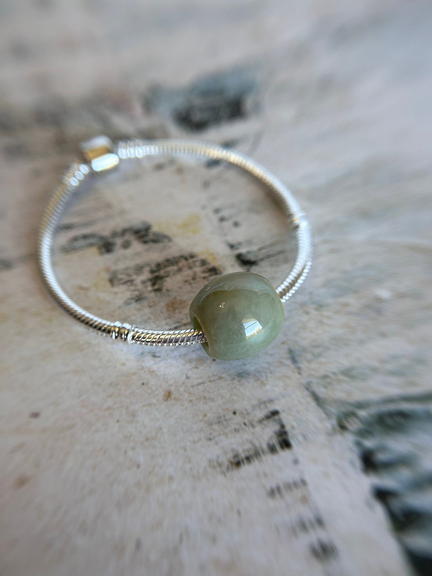 Grade A Natural Green and Yellow Burmese Jadeite Lu Lu Tong charm on a sterling silver bracelet