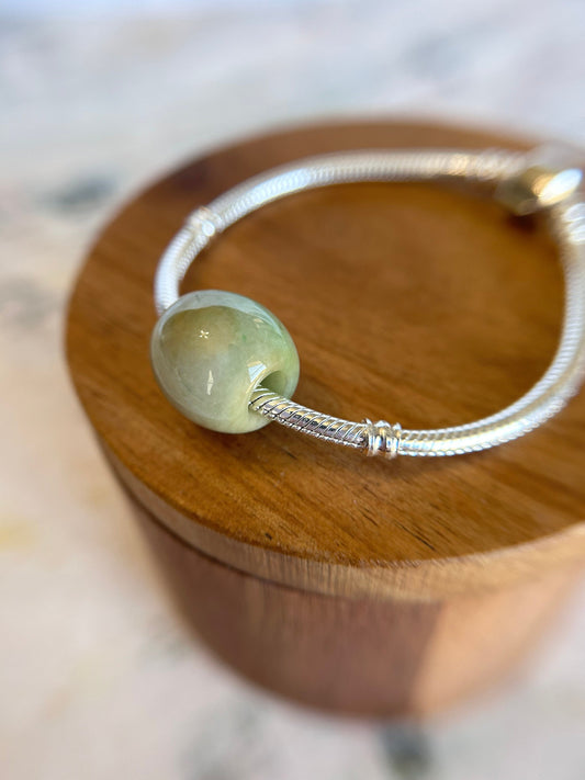 Grade A Natural Green and Yellow Burmese Jadeite Lu Lu Tong charm on a sterling silver bracelet