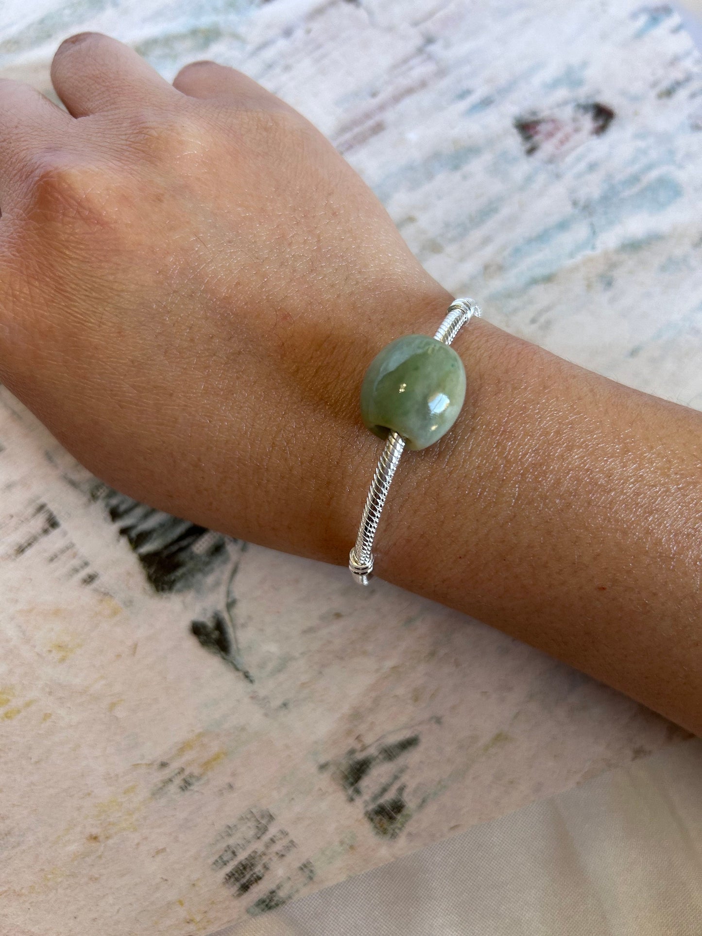 Grade A Natural Green and Yellow Burmese Jadeite Lu Lu Tong charm on a sterling silver bracelet